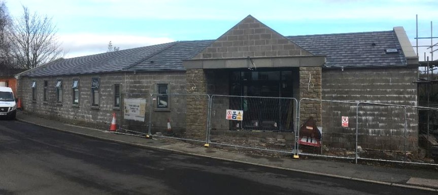 Nearly complete village hall with roof tiling on